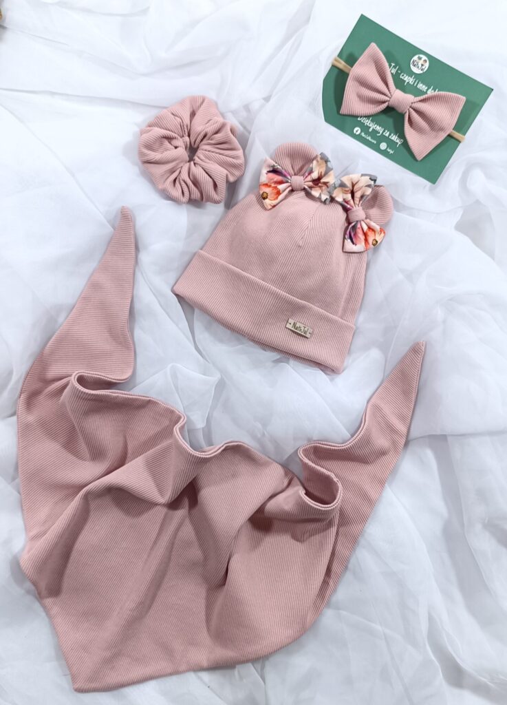 Zdjęcie kompletu czapka z uszami i kokardkami, chusta pod szyje, gumka scrunchie oraz opaska na głowę.